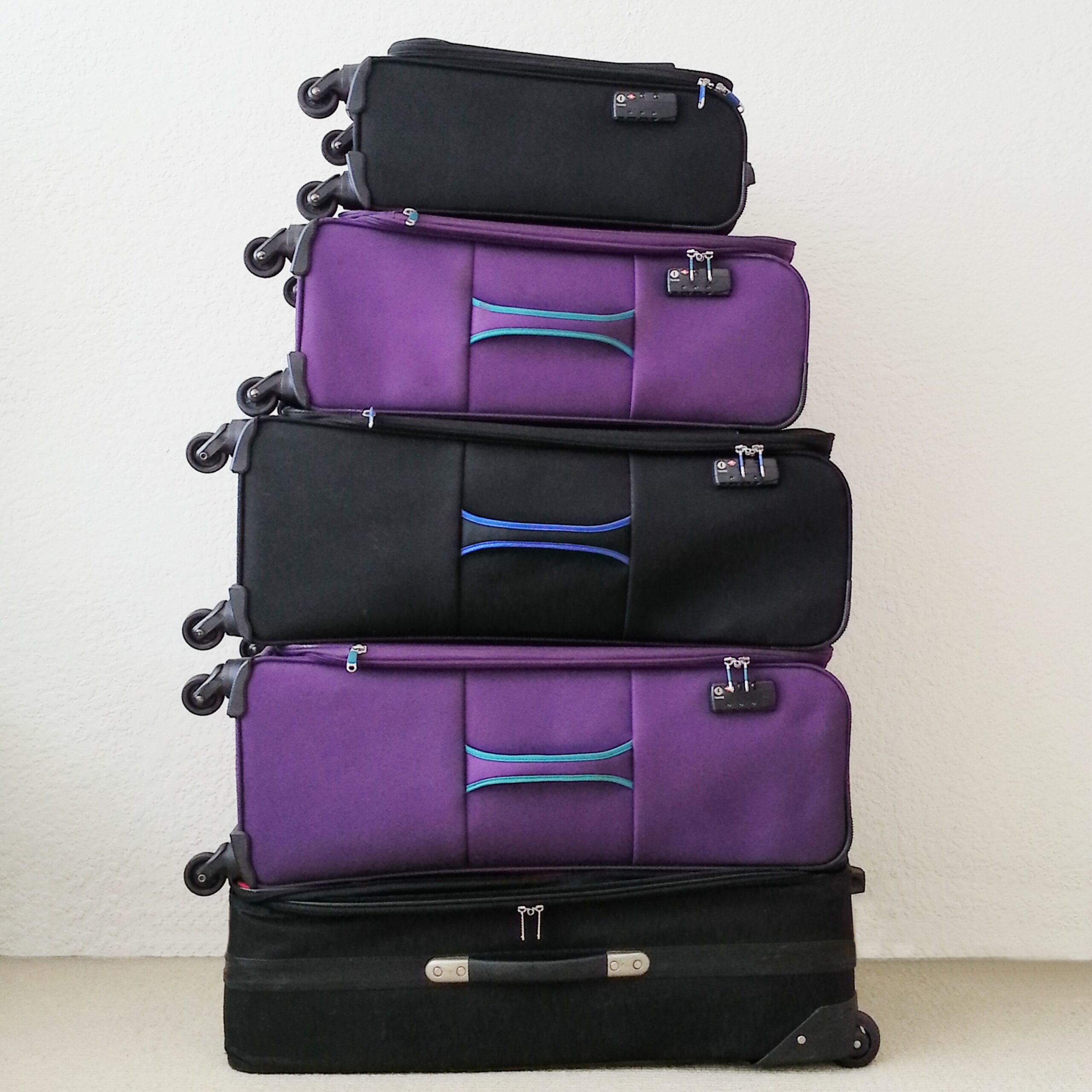 black and purple suitcases stacked